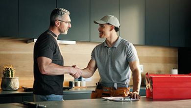 Men opening new double hung windows as  home contractor watches.
