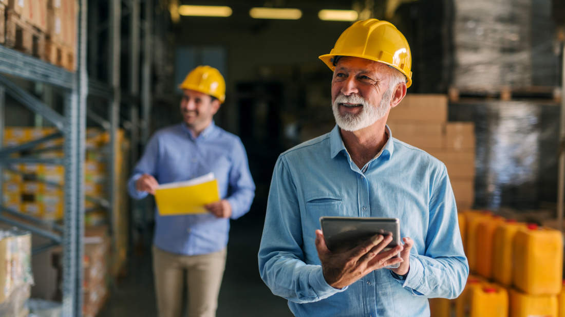 Two men checking  inventory in warehouse.